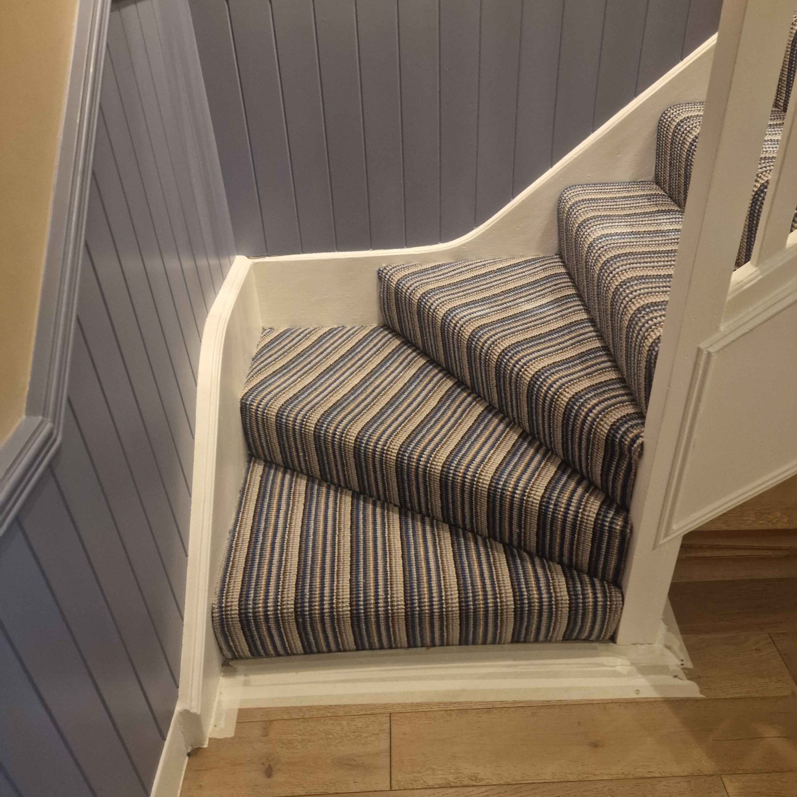 black and blue striped stair runner carpet fitted on stairs