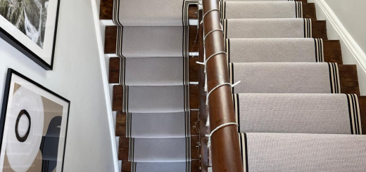 a light grey boucle loop wool stair runner and platform with a black and white striped border