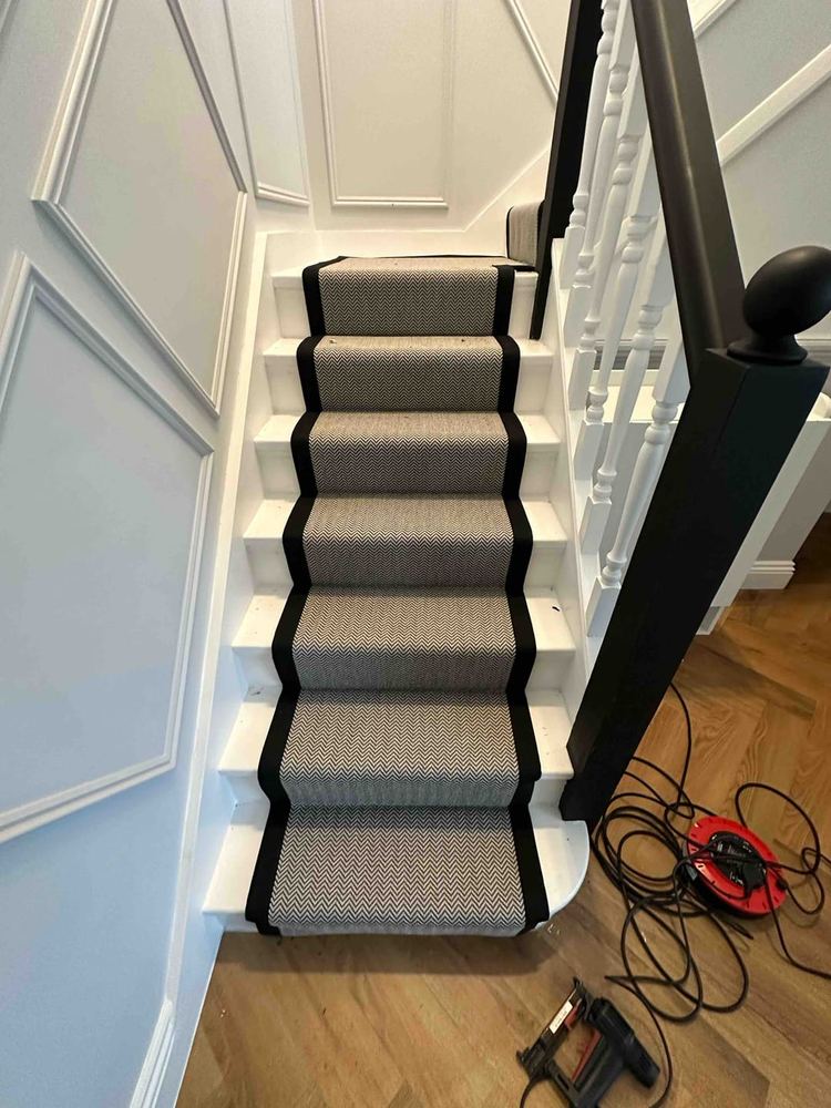 Herringbone stair runner with a narrow black bound edge
